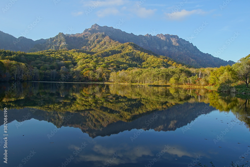 A pond that reflects trees and mountains like a mirror. At dusk. Beautiful scenery of Japan. A pond that reflects trees and mountains like a mirror. At dusk. Beautiful scenery of Japan.
