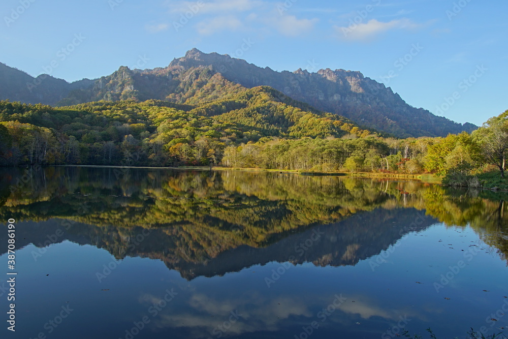 A pond that reflects trees and mountains like a mirror. At dusk. Beautiful scenery of Japan.