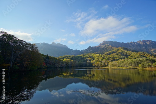 A pond that reflects trees and mountains like a mirror. At dusk. Beautiful scenery of Japan.