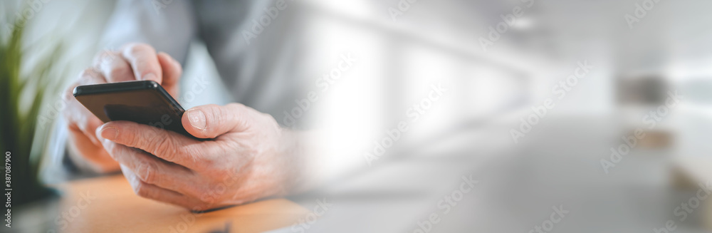 Hands using mobile phone; panoramic banner Hands using mobile phone; panoramic banner