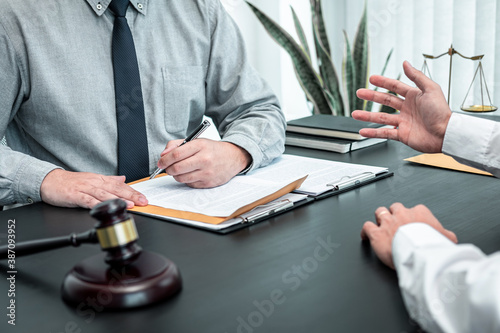Male lawyer discussing negotiation legal case with client meeting with document contact in courtroom, law and justice concept