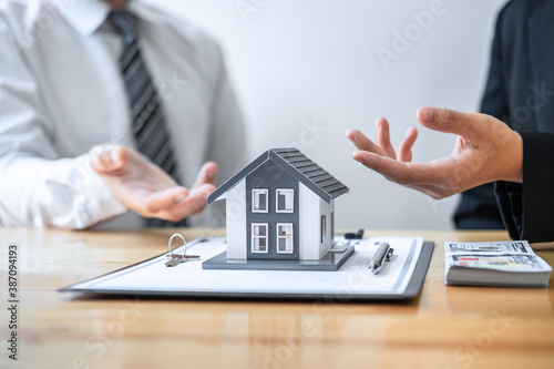 Estate agent are presenting home loan and giving house to client after discussing and signing agreement contract with approved application form, Home Insurance and Real estate investment concept