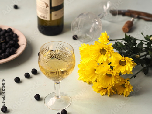 Still life with autumn flowers, chresanthem, wine and dark blackthorn berries.Two glasses for two. photo