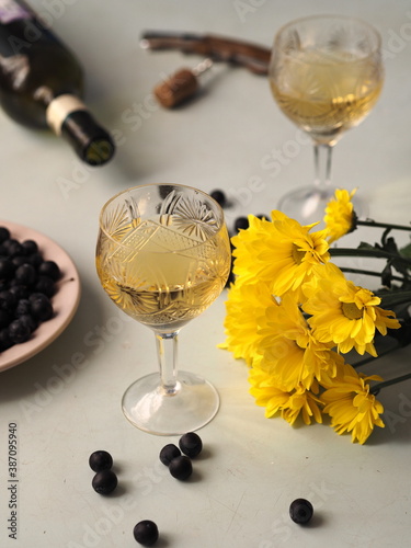 Still life with autumn flowers, chresanthem, wine and dark blackthorn berries.Two glasses for two. photo