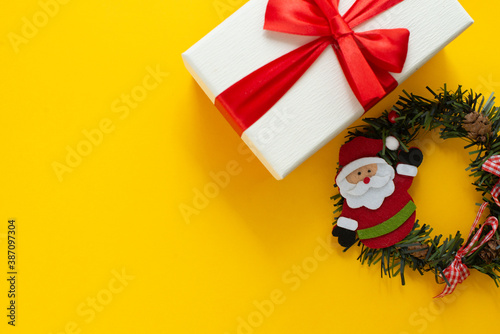 Happy New Year and Merry Christmas. Santa Claus with holiday present. Copy space, yellow background, space for text.