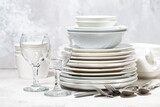 empty tableware, cutlery and glasses on a white background