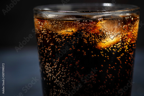 glass of coca cola with ice on a dark background, closeup