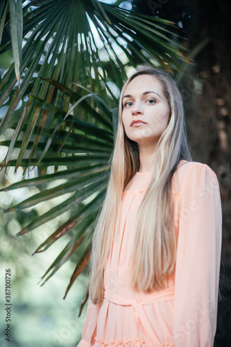 Portrait of a young,  gorgeous woman with beautiful long hair in summer park.