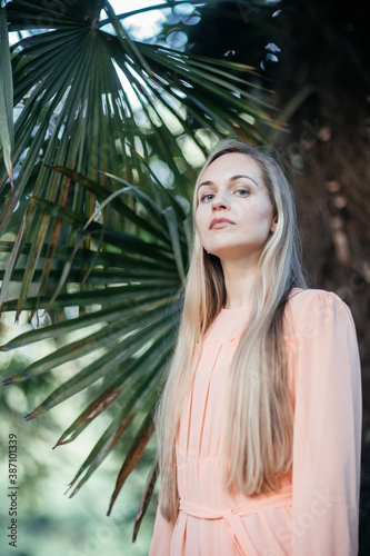 Portrait of a young,  gorgeous woman with beautiful long hair in summer park.