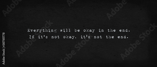 Everything will be okay in the end. If it's not okay, it's not the end. Powerful quote, minimalist text art illustration, dark background, typewriter font style. Conceptual lettering for thinking. photo