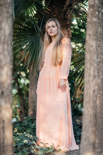 Portrait of a young,  gorgeous woman with beautiful long hair in summer park.