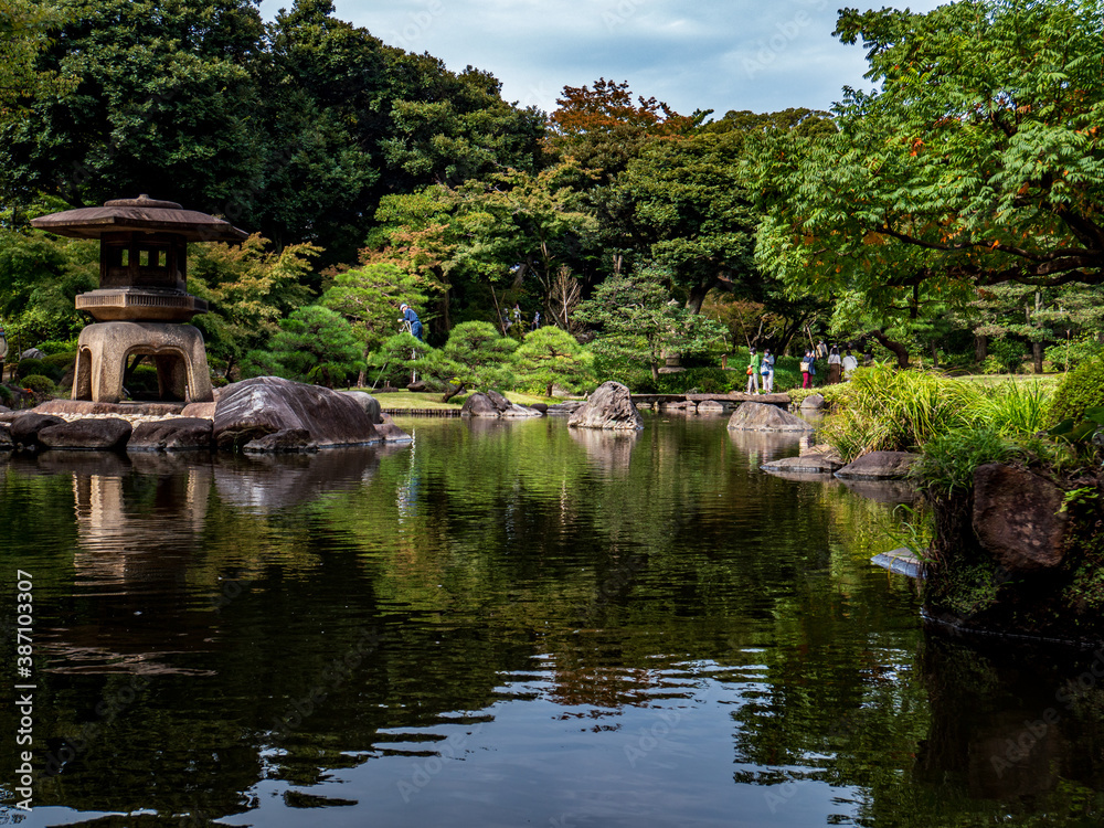 池のある、秋の日本の伝統的な庭園の風景