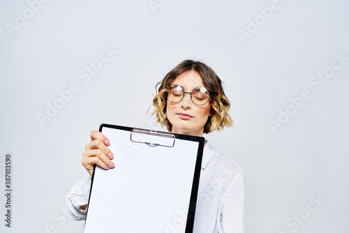 Business woman with a folder of white documents in her hand on a light background And hairstyle glasses model