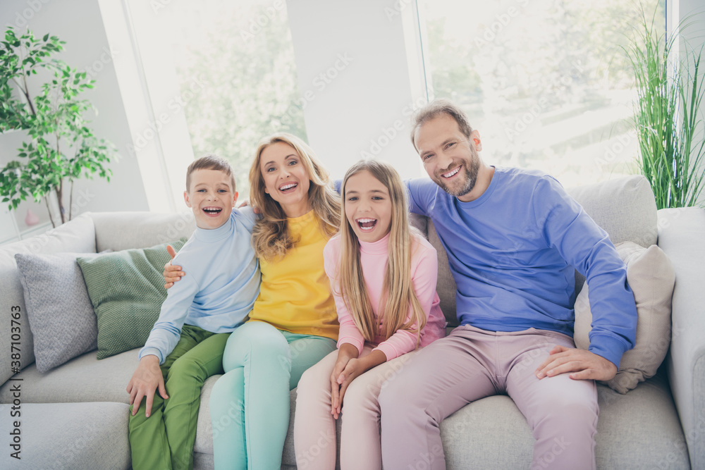 Photo of cozy harmony family sit couch mommy daddy two kids boy girl watch funny cartoon in house indoors