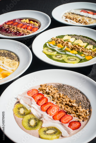 A selection of five different Smoothie bowl with different fruits, yogurt, granola and nut seeds