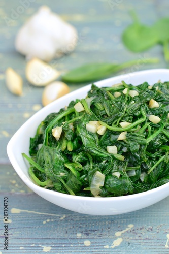 Sauteed garlic spinach. Healthy diet vegetarian. Blurred background