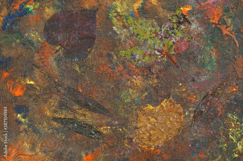Pomalowane i zatopione liście w farbie, w namalowanym, abstrakcyjnym tle, struktura.