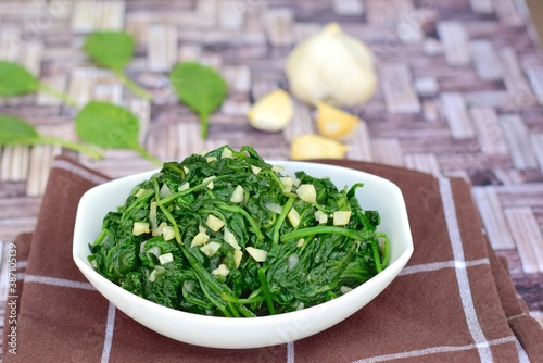 Foto Sauteed garlic spinach. Healthy diet vegetarian
