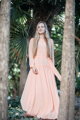 Portrait of a young,  gorgeous woman with beautiful long hair in summer park.