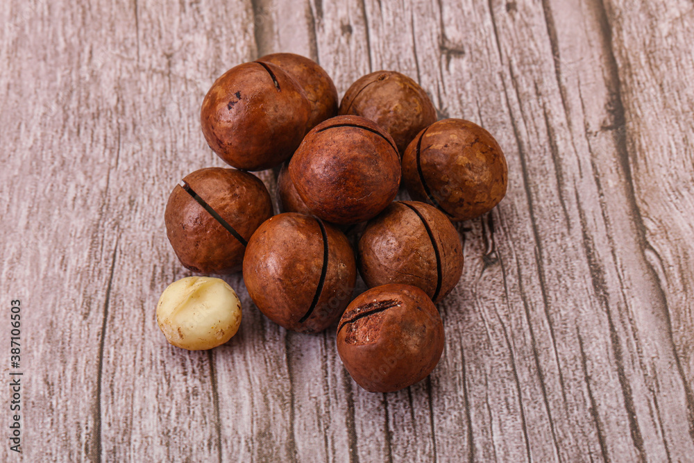 Obraz premium Brown macadamia nut heap over background