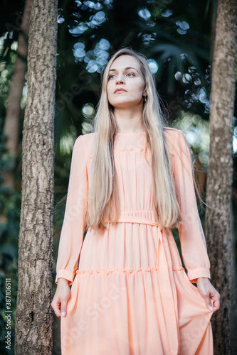 Portrait of a young,  gorgeous woman with beautiful long hair in summer park.