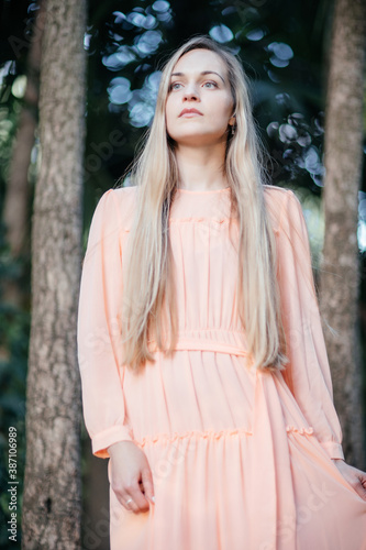 Portrait of a young,  gorgeous woman with beautiful long hair in summer park.