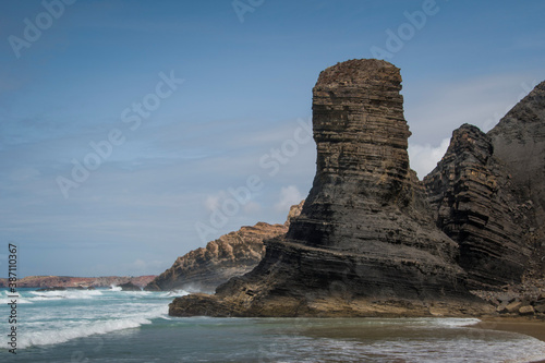 schist rock formations standing on beach