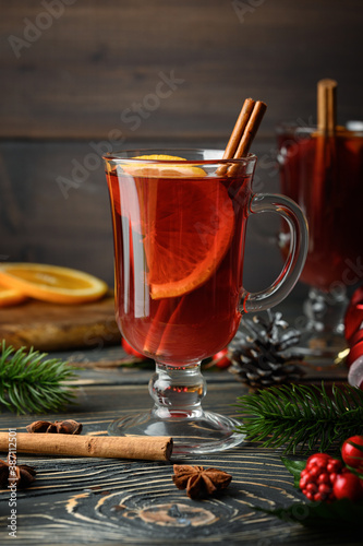 Glass with Christmas mulled wine, orange and cinnamon. Holiday atmosphere. Close-up photo.