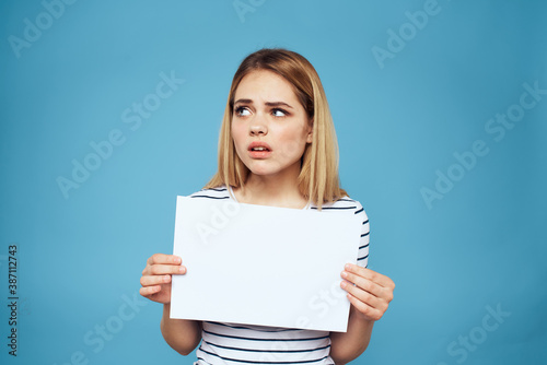 Emotional woman holding a sheet of paper in her hands lifestyle close-up blue background Copy Space