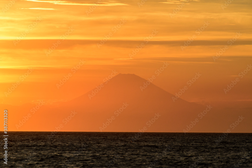 夕日に映えｵﾚﾝｼﾞ色に輝く洋上の富士山