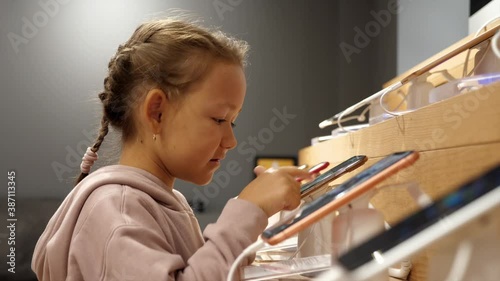 Wallpaper Mural Little child using new smartphone on counter in an electronics store. Cute kid girl is touching screen of mobile phone in retail store. Torontodigital.ca