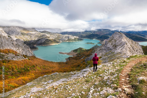 Chica de espaldas observando lago de Riaño desde la montaña 