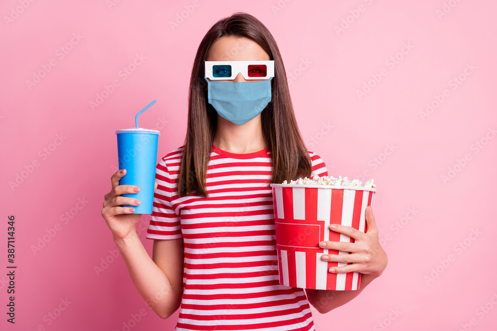 Photo portrait of happy girl wearing 3d glasses holding box with pop corn keeping cup of soda wearing blue face mask isolated on pastel pink color background - obrazy, fototapety, plakaty 