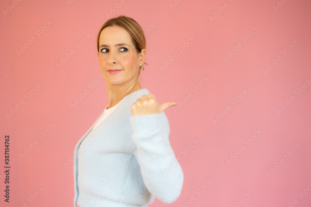 Young woman wearing casual sweater over isolated pink background doing happy thumbs up gesture with hand. Approving expression looking at the camera with showing success. Young woman wearing casual sweater over isolated pink background doing happy thumbs up gesture with hand. Approving expression looking at the camera with showing success.