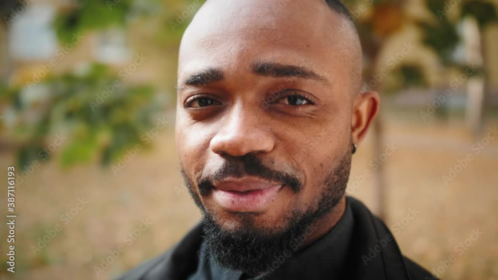 Portrait of mixed race man smiling looking to camera. Friendly handsome happy african american person face outdoors Portrait of mixed race man smiling looking to camera. Friendly handsome happy african american person face outdoors