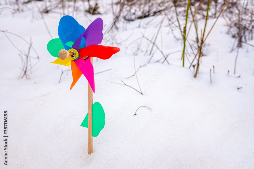 Colorful toy pinwheel on the white snow, background with copy space. Colorful toy pinwheel on the white snow, background with copy space.