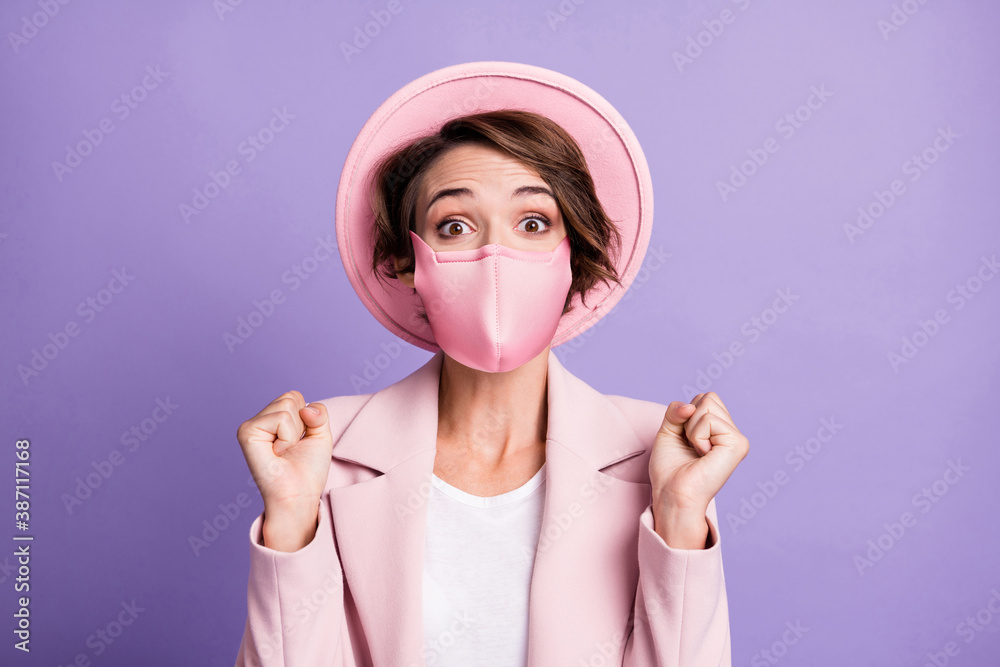 Photo of curly lucky lovely woman wear medical mask pink vintage blazer cap arms fists isolated violet color background Photo of curly lucky lovely woman wear medical mask pink vintage blazer cap arms fists isolated violet color background