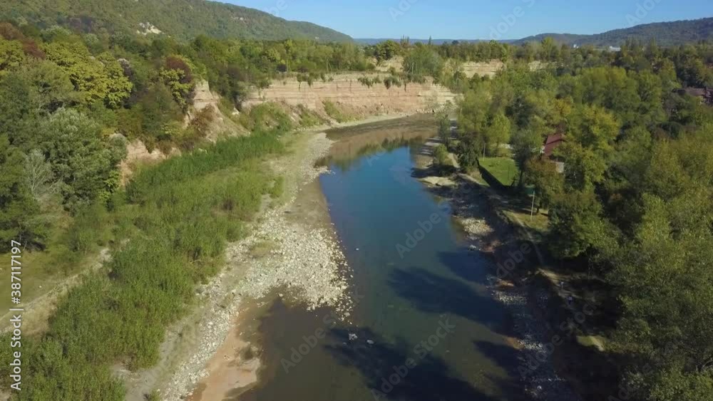 Calm slow mountain river. The drone slowly flies over the surface of the river Calm slow mountain river. The drone slowly flies over the surface of the river