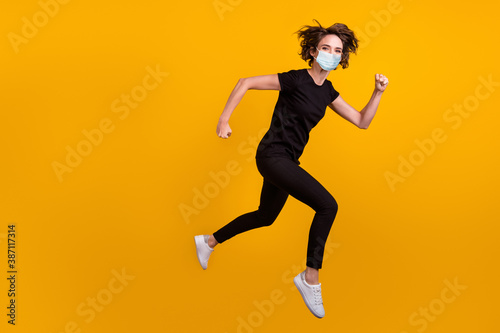 Full length body photo of girl jumping running shopping center use medical mask isolated yellow color background