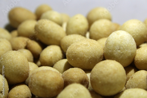 Close up savory and crunchy coated nut snacks on white background