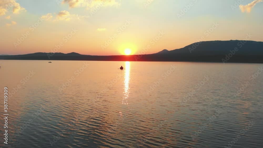 People sailing on the boats with paddles on the river on sunset People sailing on the boats with paddles on the river on sunset