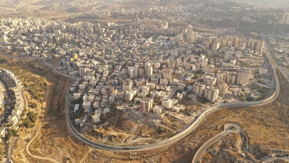 Israel and Palestine divided by Security wall Aerial view
Aerial view of Left side Anata Palestinian town and Israeli neighbourhood Pisgat zeev  
