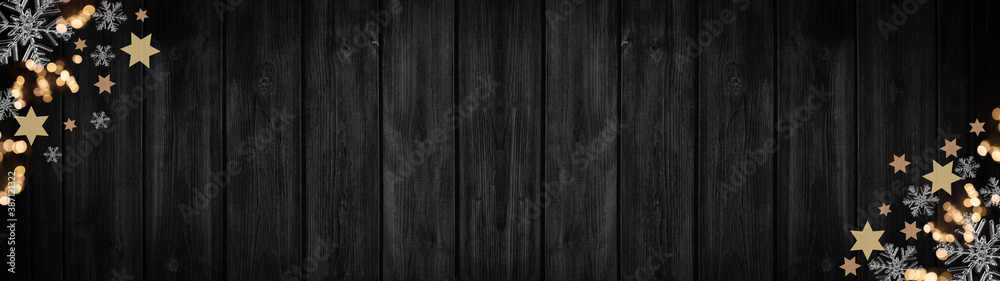 Fototapeta premium Festive decorative Christmas / Advent background banner panorama template - Bokeh lights, stars and ice crystals, isolated on dark black rustic wooden boards wall texture, with space for text