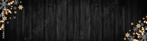 Festive decorative Christmas / Advent background banner panorama template - Bokeh lights, stars and ice crystals, isolated on dark black rustic wooden boards wall texture, with space for text