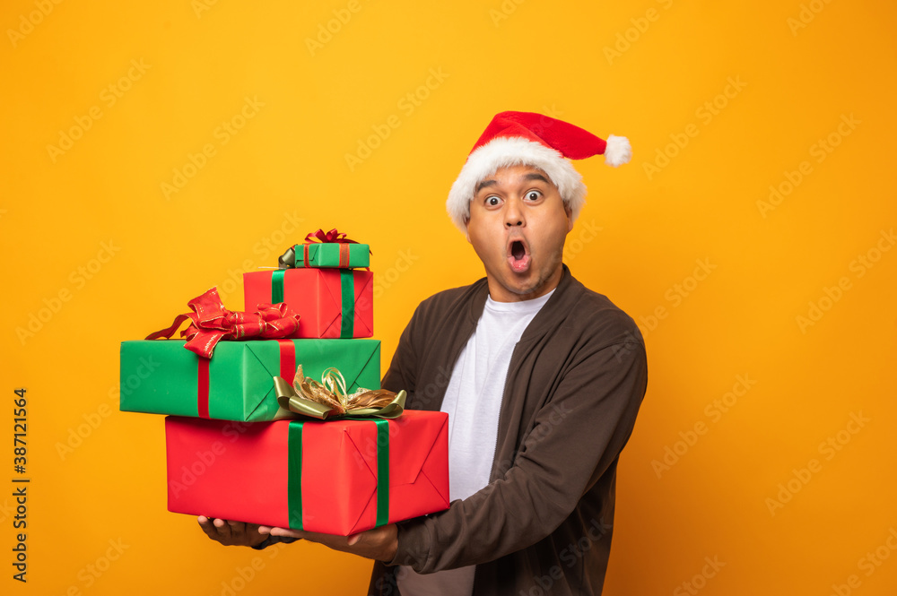 Happy excited asian man in new year's christmas day holding the Happy excited asian man in new year's christmas day holding the