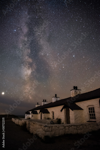 The Milky Way over Llanddwyn pilots cottages at Ynys Llanddwyn on Anglesey, North Wales. photo