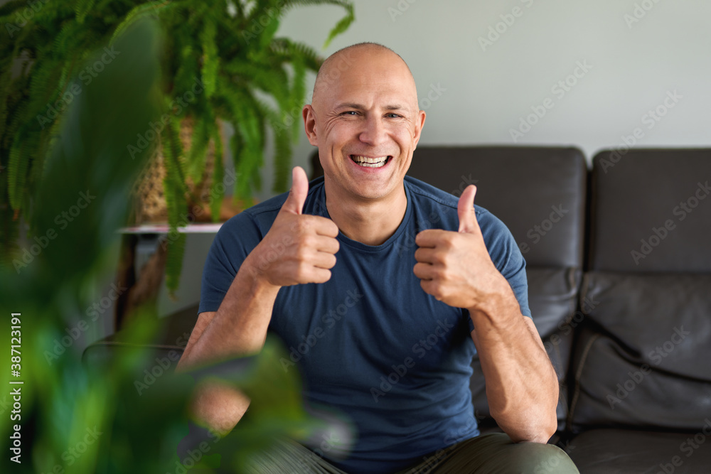Portrait of man looking at camera while sitting on sofa Portrait of man looking at camera while sitting on sofa