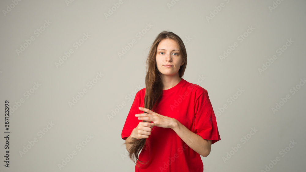 girl on a gray background holds a hair in her hand girl on a gray background holds a hair in her hand