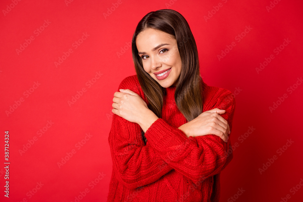 Photo of lovely girl hug herself isolated over vivid red color background Photo of lovely girl hug herself isolated over vivid red color background