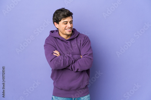 Young cool man smiling confident with crossed arms.